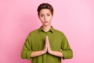 Photo of unhappy sad young lady wear green blouse arms together asking forgiveness isolated pink...