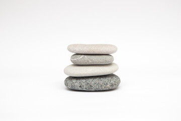 Flat gray pebbles on a white background in a stack
