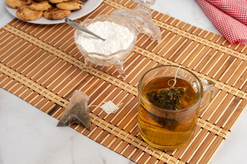 cup of tea with tea bag with plate with chocolate cookies for snack or breakfast