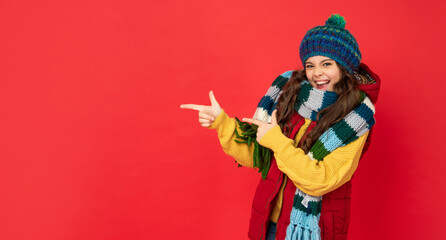 pointing finger on copy space. happy kid with curly hair in hat. female fashion model.