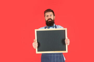 Anxious bearded man hold blackboard. Barbershop price board. Barbershop advertising, copy space