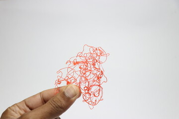 PLA plastic filaments held in hand left out from overhanging while 3d printing process, waste...