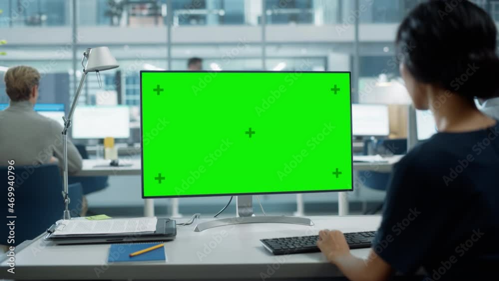 Poster Close Up Over the Shoulder Shot of a Businesswoman Working on Desktop Computer with Chroma Key Green Screen Mock Up Display. Digital Projects Manager Typing Data, Using Keyboard and Mouse.