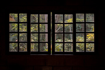 A window with Atlantic Forest view, viewed form the inside of a country home, Rio de Janeiro, Brazil