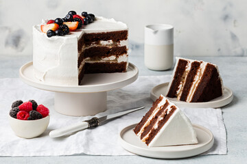 festive white cake decorated fresh beries on white cake stand, white background