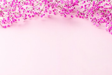 round frame wreath pattern with gypsophila flower, pink flower buds, branches and leaves on light pink background. flat lay, top view