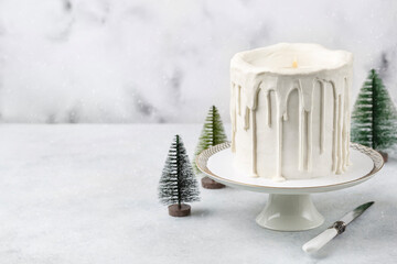 Сake in the shape of a candle. Christmas white cake on a white background with a Christmas decoration, lights or winter holidays pastry food concept.