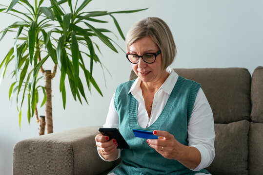 Woman entering bank card data on smartphone for online order