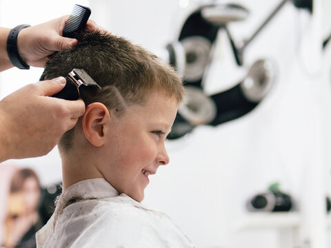 Little boy getting haircut in barbershop