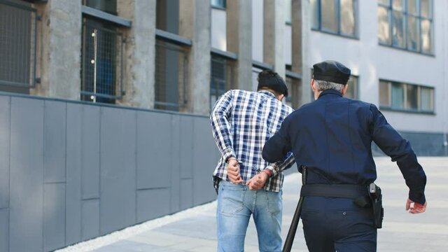 Arrest of the offender in the city. Detention of the accused man person. Police man leads a criminal. Detention of the accused