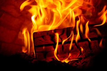 Fototapeta premium Burning log of wood in a fireplace close-up.