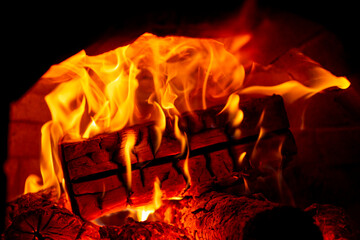 Burning log of wood in a fireplace close-up.