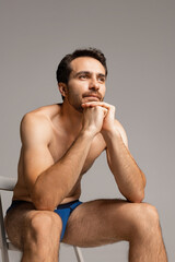 Fototapeta premium Close-up portrait of young handsome bearded shirtless man isolated on gray studio background. Natural beauty