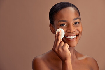 Black beautiful woman using cotton pad to remove make up - obrazy, fototapety, plakaty