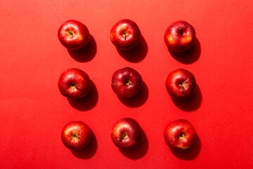 Many red apples on colored background, top view. Autumn pattern with fresh apple above view