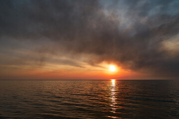 Obraz premium Sea sunset. Smoke wildfires sweeping across the sky.