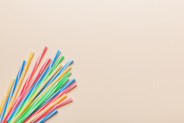 Heap of colorful plastic drinking straws on Colored background, flat lay. Copy Space for text