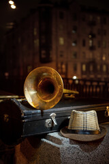 Trombone, men's hat and night city