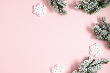 Fototapeta na wymiar Christmas holiday composition. Christmas decor, fir tree branches, snowflake on pastel pink background. Xmas, winter, new year concept. Flat lay, top view, copy space
