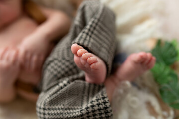 a small leg of the newborn in a white scarf. soft focus