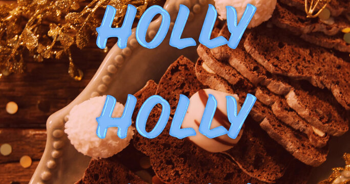 Image of holly text in repetition over christmas decorations