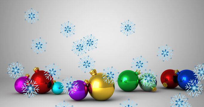 Image of snow falling over christmas baubles