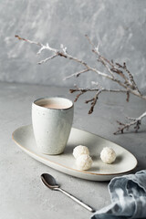A cup of hot chocolate or cacao, cookies on a plate. Grey wintwe background. Comfort zone concept.