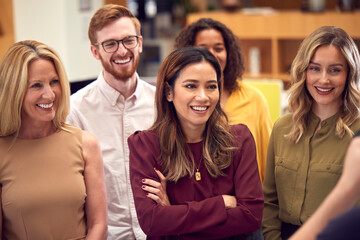 Portrait Of Smiling Multi-Cultural Business Team Standing In Modern Open Plan Office