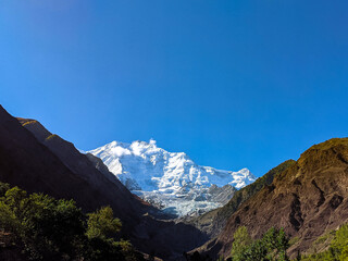 A Snow Capped Mountain Peak Seen Between Two Huge Mountains, Called Rakaposhi Peak, Located In Gilgit-Baltistan, Pakistan
