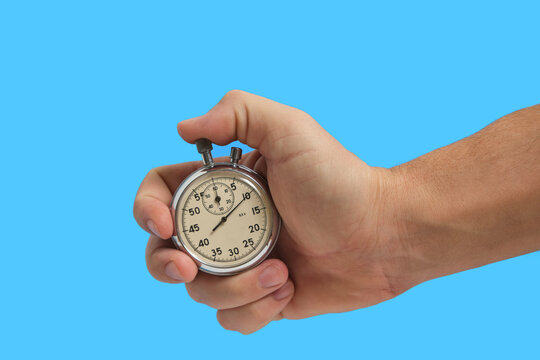 Man hand holding stopwatch on blue background.