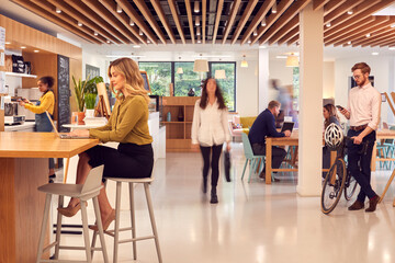 Interior Of Busy Office Coffee Shop With Businesspeople Working At Tables