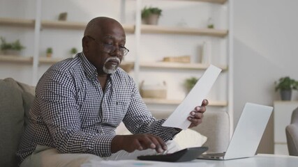 Retirement financial planning concept. Senior african american man managing account finances, calculating budget tax