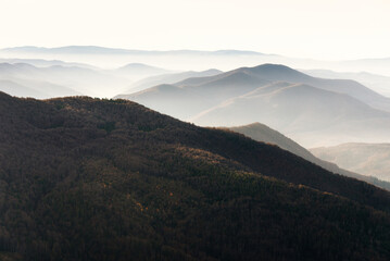 Beautiful landscape of autumn mountains layers range at  hazy morning. A view of the misty slopes...