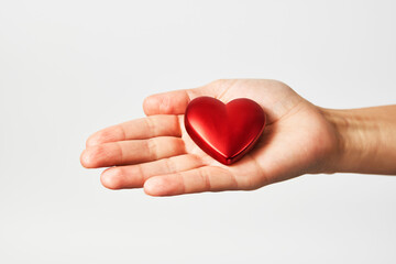 Hands holding red heart, close-up, white background