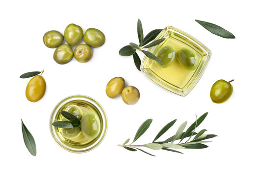 Bowls of oil, ripe olives and leaves on white background, top view