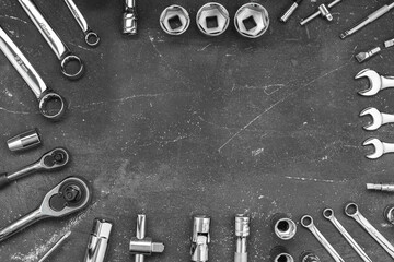Wrenches and other auto tools on a dark background, copy space in the center