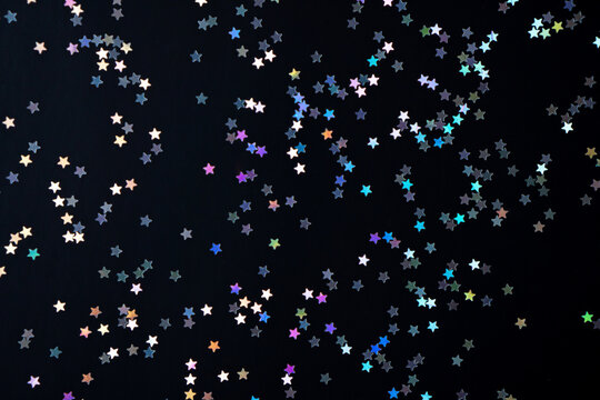 Festive black paper background with many many silver stars. Christmas, New Year or Birthday theme concept. An ideal backdrop for your banner or web design. Banner for happy holidays presentation