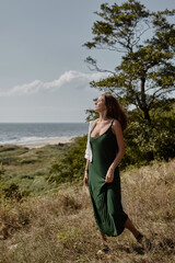 Sensual woman in a long dress against the background of the sea

