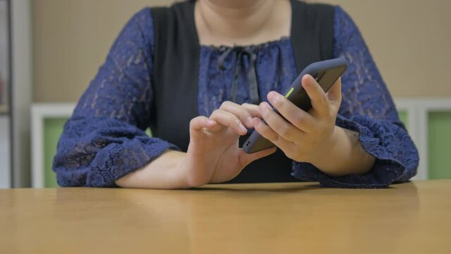 Disabled blind person woman in wireless earphones using smart phone with voice accessibility technology for persons with disabilities in office workplace..