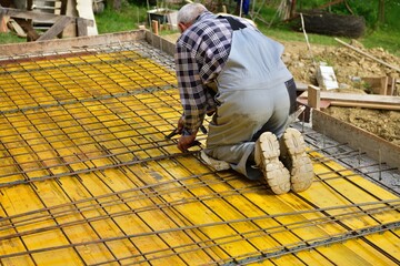 The mason connects with pliers by hand wires to the formwork walls for concreting