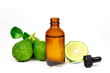 Bergamot oil in bottle and fresh bergamot fruit with green leaf isolated on white background.