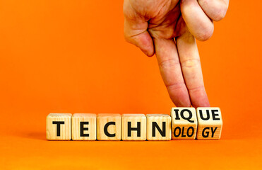 Technique and technology symbol. Businessman turns wooden cubes, changes the technology to technique. Beautiful orange table, orange background. Business technique and technology concept. Copy space.