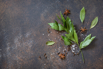 Culinary food background. Bay leaves with garlic, bay leaves and pepper on a stone dark table. Top view flat lay background. Copy space.