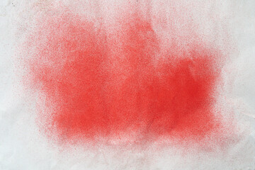 red spray paint on a white colored paper background