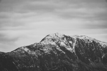 Dramatic snowy peak of the mountain in Norway, Alesund. Scandinavian vibe. Black and white.