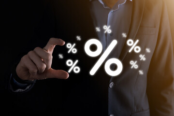 Male hand holding interest rate percent icon on blue background. Interest rate financial and mortgage rates concept.Banner with copy space