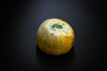 a rotten lemon on a black background