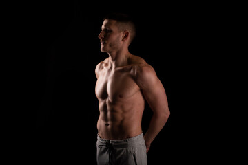 Fototapeta na wymiar Man Showing ABS. Muscle man Posing. Strong Body Concept. Topless Sport man Bodybuilder. Six Pack Spotsman. Hands Behind Back