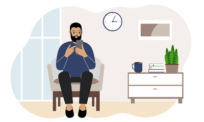 Happy man busy with mobile phone, sitting in a chair in the living room. Rest and work at home.