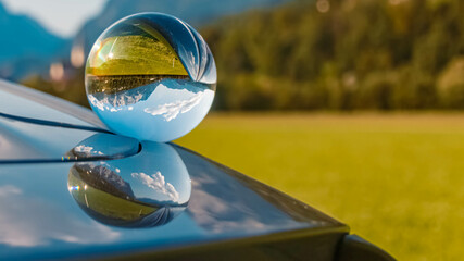 Crystal ball landscape shot with reflections on a car roof and the famous Tennengebirge mountains...